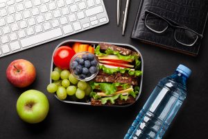 alimentación saludable en el trabajo, comida y agua en un escritorio