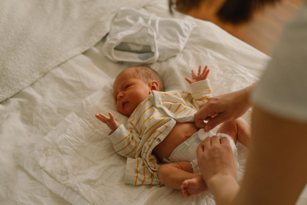 padres primerizos cambiando el pañal a su bebé