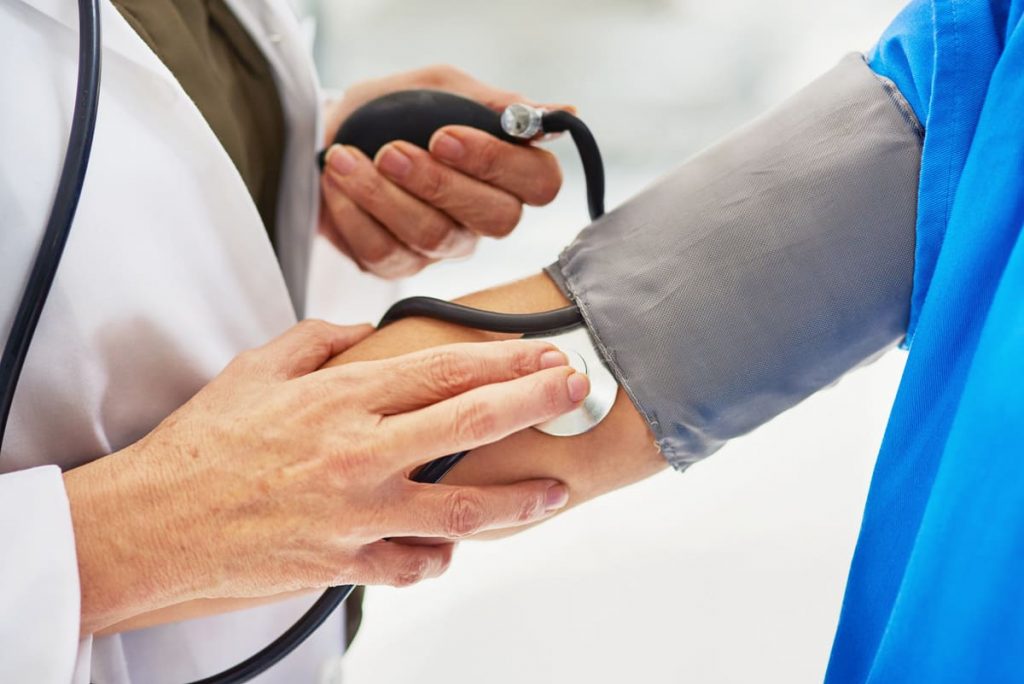 médico tomando la tensión a un paciente para chequeo médico completo