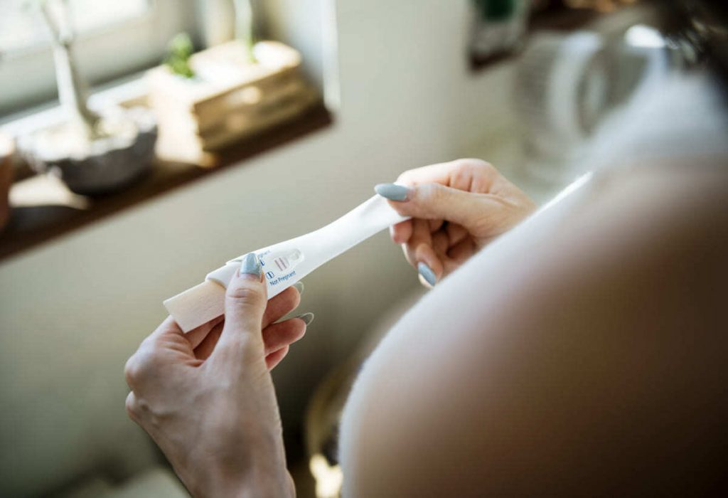 mujer leyendo un test de embarazo en primer mes embarazo