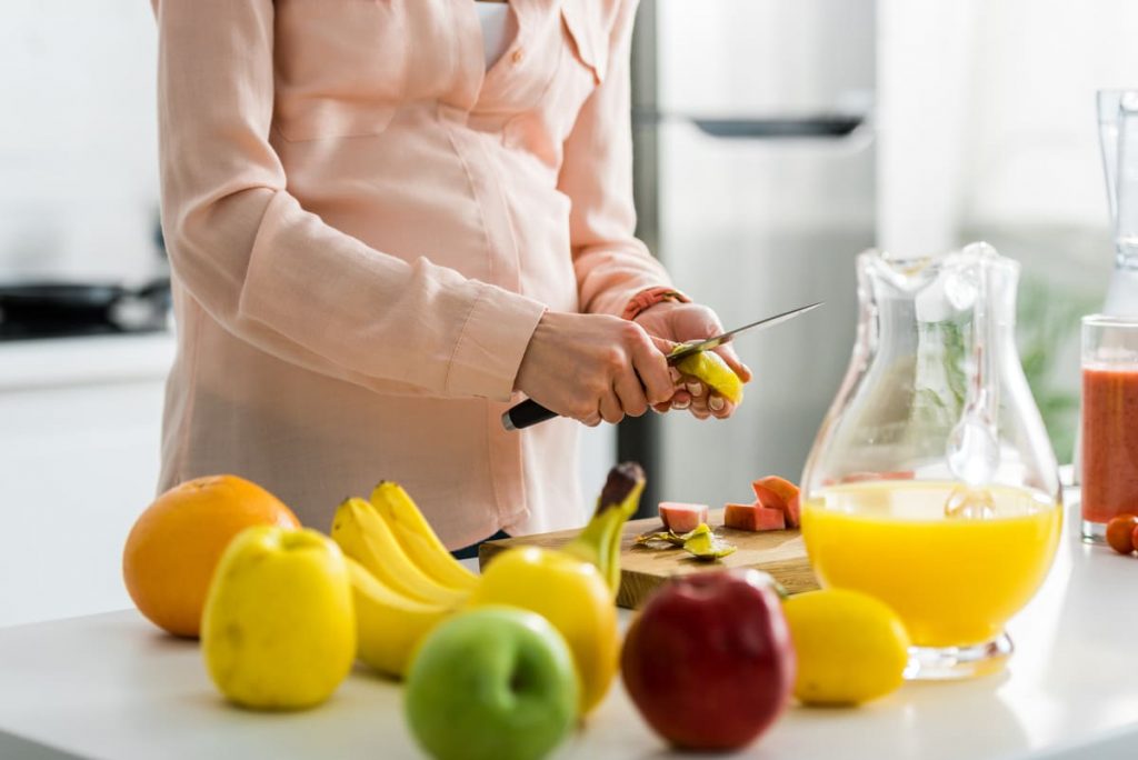 mujer embarzada cocinando comida saludable antes de tener un bebé
