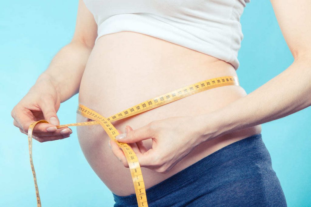 mujer midiéndose la barriga en el primer mes embarazo
