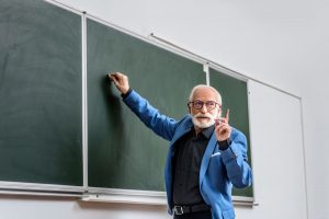 un profesor escribiendo en la pizarra antes de jubilación profesor